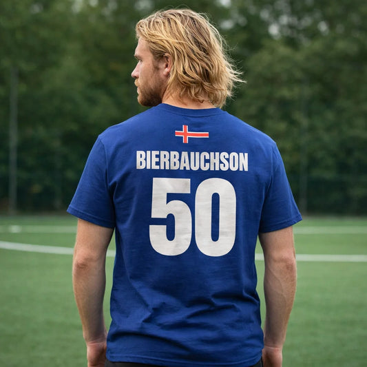 Dunkelblaues Island Saufshirt getragen von Mann auf dem Sportplatz, Rückenprint BIERBAUCHSON 50 und Island-Flagge oben.