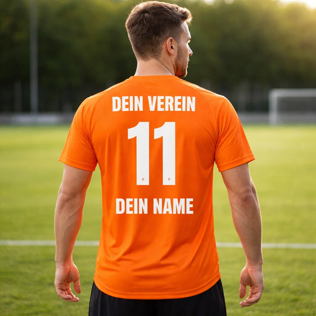 Rückansicht: orange Trikot mit „DEIN VEREIN“, Nummer 11 und „DEIN NAME“, getragen von Mann auf Sportplatz, Team Trikot.